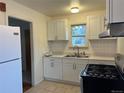 Bright kitchen with white cabinets, tile backsplash, and modern appliances, perfect for cooking enthusiasts at 5899 Vance St, Arvada, CO 80003