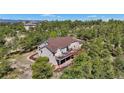 Beautiful aerial view shows the home surrounded by trees and outdoor living space at 17575 Minglewood Trl, Monument, CO 80132