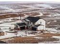 Charming two-story house on a sprawling lot features brick accents, two garage doors and snow covered ground at 3654 Paintbrush Ln, Parker, CO 80138