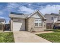 Charming brick home with attached garage, complemented by a lush green lawn and clear blue skies at 4912 Altura St, Denver, CO 80239