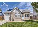 Charming brick home featuring a well-manicured lawn, attached garage, and inviting front entrance at 4912 Altura St, Denver, CO 80239