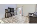 Bright living area showcasing neutral tile flooring, sliding glass doors and modern decor at 4912 Altura St, Denver, CO 80239