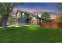 View of the home showing the manicured lawn and mature trees surrounding the property at 6735 W 97Th Cir, Westminster, CO 80021