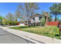 Well-manicured lawn and mature trees surround this charming home with brick accents and a two car attached garage at 12978 Dexter St, Thornton, CO 80241