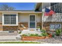 Charming entrance with decorative brick, an American flag, and lovely landscaping creating a welcoming curb appeal at 12978 Dexter St, Thornton, CO 80241