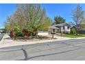 Inviting exterior with mature trees, a well-kept lawn, and a cozy home, featuring a charming wooden fence at 12978 Dexter St, Thornton, CO 80241