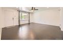 Bright living room with hardwood floors, a ceiling fan, and a large window at 10633 E 6Th Pl, Aurora, CO 80010