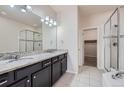 Modern bathroom with double vanity, granite countertops, and a glass-enclosed shower at 6634 S Patsburg St, Aurora, CO 80016
