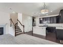 Inviting open-concept kitchen boasts sleek dark cabinetry, stainless steel appliances, and an island at 6634 S Patsburg St, Aurora, CO 80016
