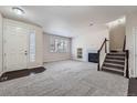 Bright living room featuring neutral decor, a fireplace, and a staircase leading to the upper level at 6634 S Patsburg St, Aurora, CO 80016