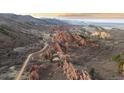 Stunning aerial view of the home nestled among red rock formations and rugged mountain landscape at 3755 N Rampart Range Rd, Littleton, CO 80125