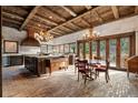 Gourmet kitchen featuring exposed beam ceilings, brick floors, large island and outdoor views at 3755 N Rampart Range Rd, Littleton, CO 80125