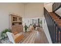 Bright living room with hardwood floors, a staircase, a large cabinet and an open dining room at 11570 Depew Ct, Westminster, CO 80020