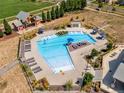 Aerial view of a resort-style pool with lounge chairs and a surrounding park at 17806 E 103Rd Ave, Commerce City, CO 80022