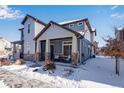 Two-story house with gray siding, stone accents, and a covered porch at 17806 E 103Rd Ave, Commerce City, CO 80022