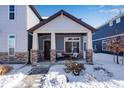 Covered porch with stone columns and seating area at 17806 E 103Rd Ave, Commerce City, CO 80022