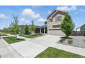 Suburban home on a tree-lined street featuring a well-kept lawn and an attached garage at 27125 E Bayaud Ave, Aurora, CO 80018