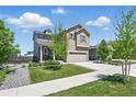 Attractive two-story home showcasing a lush green lawn, young trees, and neutral color palette at 27125 E Bayaud Ave, Aurora, CO 80018