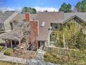 Aerial view of townhome, with brick chimney, neutral siding and landscaped front yard, walkway to inviting front entrance at 7707 S Curtice Way # D, Littleton, CO 80120