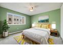 Cozy bedroom with bright green walls, a large window, and a comfortable bed with decorative pillows at 1045 N Pennsylvania St # 303, Denver, CO 80203