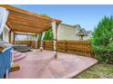 Outdoor living space featuring a pergola with string lights and curtains, a hot tub, and a privacy fence at 449 Vista Blvd, Lochbuie, CO 80603