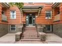 Entryway stairs leading up to building with brick walls and wrought iron railing at 1356 N Pearl St # 109, Denver, CO 80203