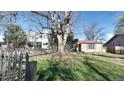 Quaint home nestled in a lush, green front yard with a vintage picket fence adding character and charm at 2572 S Vine St, Denver, CO 80210