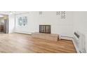 Open-concept living room with decorative fireplace, hardwood floors and view of the kitchen at 250 N Pearl St # 310, Denver, CO 80203