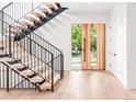 Bright entryway boasting light wood floors, floating stairs with iron railing, and a statement front door at 1466 S Gaylord St, Denver, CO 80210