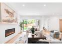 Bright living room with a modern fireplace, hardwood floors and sliding glass doors to the backyard at 1466 S Gaylord St, Denver, CO 80210