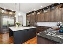 Gourmet kitchen features dark wood cabinets, stainless appliances, and a marble top island at 2121 Jade Way, Longmont, CO 80504