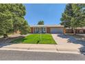 Charming single-story home with brick exterior, lush green lawn, mature trees, and a two-car garage at 912 S Kingston St, Aurora, CO 80012