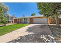 Attractive brick home with attached two-car garage, front lawn, and mature shade trees at 912 S Kingston St, Aurora, CO 80012