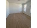 Bright, modern bedroom with wood-look flooring and two large windows at 2184 S Gold Bug Ct, Aurora, CO 80018