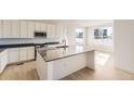 Modern kitchen with white cabinets, gray countertops, stainless steel appliances, and a large island at 2184 S Gold Bug Ct, Aurora, CO 80018
