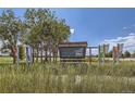 Scenic view of Aurora Sports Park sign with vibrant flags, and lush greenery against a clear blue sky at 2184 S Gold Bug Ct, Aurora, CO 80018