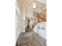 Inviting foyer with hardwood floors, a staircase, and plenty of natural light at 8114 Briar Ridge Dr, Castle Pines, CO 80108