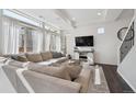 Bright living room showcases a large sectional sofa, TV, and abundant natural light from large windows at 10011 Yampa Ct, Commerce City, CO 80022