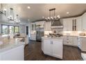 Spacious kitchen with an island, stainless steel appliances, hardwood flooring, and modern lighting fixtures at 5767 Pelican Shores Dr, Longmont, CO 80504