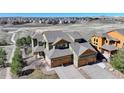A beautiful aerial view of the home featuring a three-car garage and landscaped front yard at 18338 E Saskatoon Pl, Parker, CO 80134