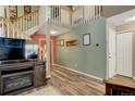 Spacious entryway with wood floors, staircase, and neutral wall paint at 7840 S Windermere Cir, Littleton, CO 80120
