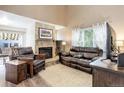 Comfortable living room with stone fireplace, vaulted ceiling, and abundant natural light at 7840 S Windermere Cir, Littleton, CO 80120