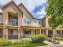 Charming brick and siding townhome with a wrought iron fenced front yard and covered porch at 600 E Dry Creek Pl, Littleton, CO 80122