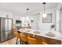 Bright eat-in kitchen features stainless steel appliances and breakfast bar with stylish pendant lighting at 862 Pontiac St, Denver, CO 80220