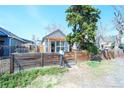 Charming home featuring a wooden fence, lush landscaping, and a pergola-covered entryway at 3735 Inca St, Denver, CO 80211