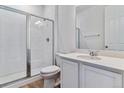 Modern bathroom features a tiled shower with glass doors, a stylish vanity, and a white ceramic toilet at 9153 Truckee Ct, Commerce City, CO 80022