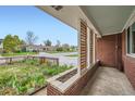 Covered front porch with brick accents, a charming garden, and a neighborhood view at 1740 S Estes St, Lakewood, CO 80232