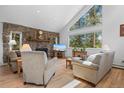 Cozy living room with a stone fireplace, large windows, and comfortable seating area at 649 Cottonwood Dr, Evergreen, CO 80439