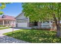 Charming home featuring manicured lawn, covered porch, and attached two-car garage at 7852 S Addison Way, Aurora, CO 80016