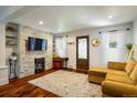 Cozy living room with a decorative fireplace, mounted TV, and hardwood floors at 3943 Newton St, Denver, CO 80211